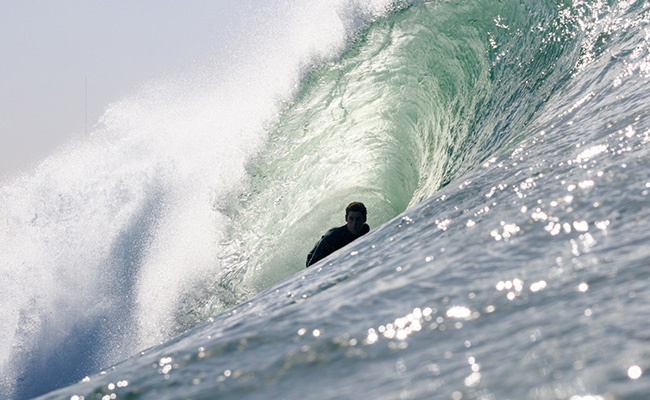 surfista poniéndose un neopreno de cremallera en el pecho