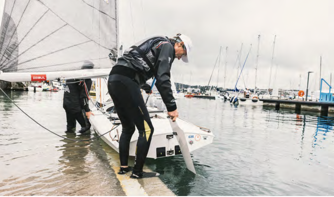 A sailor getting his boat ready to take to the seas. 