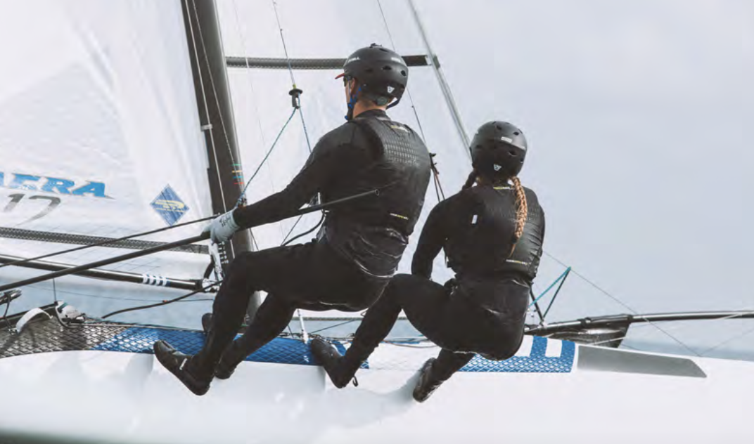 Sailors handling a boat turning on the open ocean.