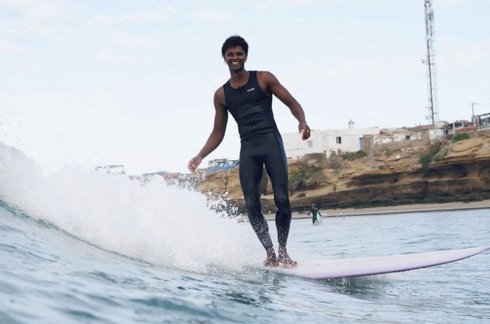 Surfer wearing a Nyord Solu Long Jane sleeveless wetsuit on a summer beach