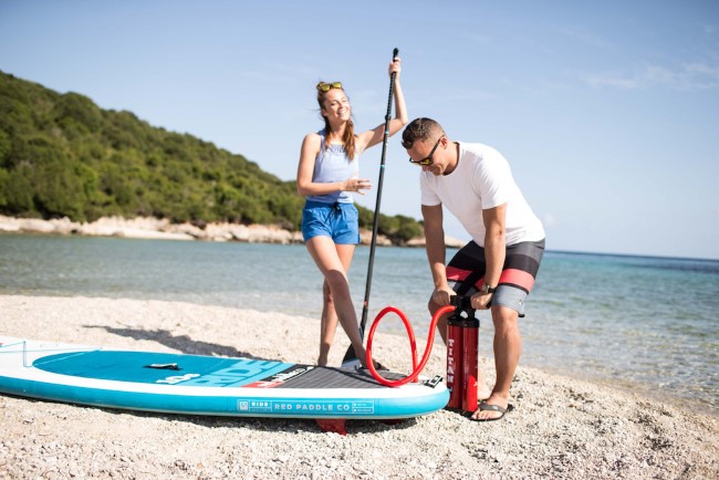 Inflating a SUP board on the sand
