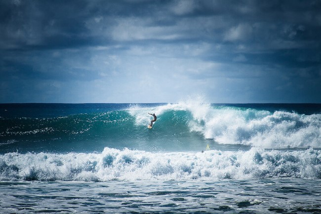 Surfer riding a wave at Barking Sands